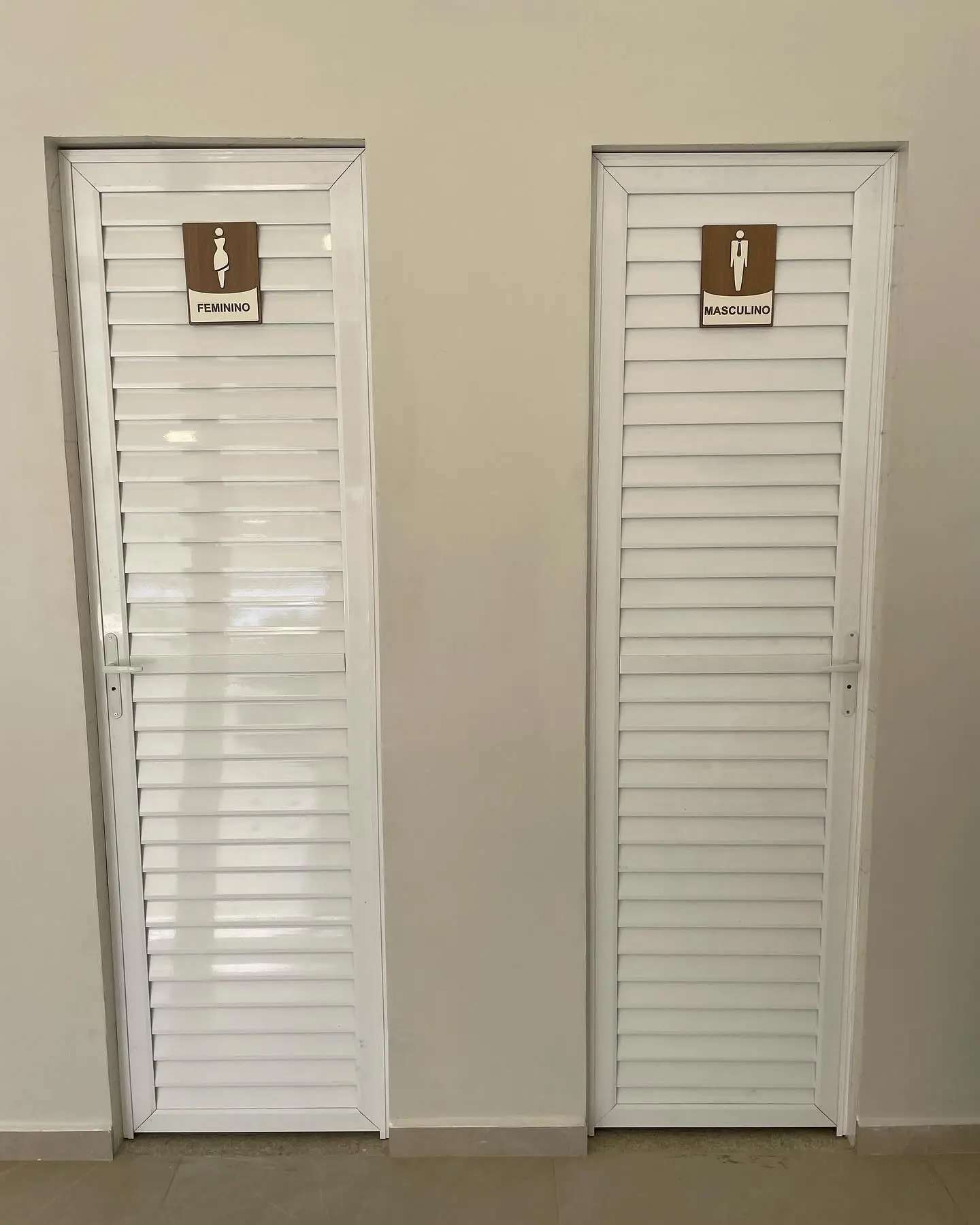 Portas brancas com placas de identificação dos banheiros