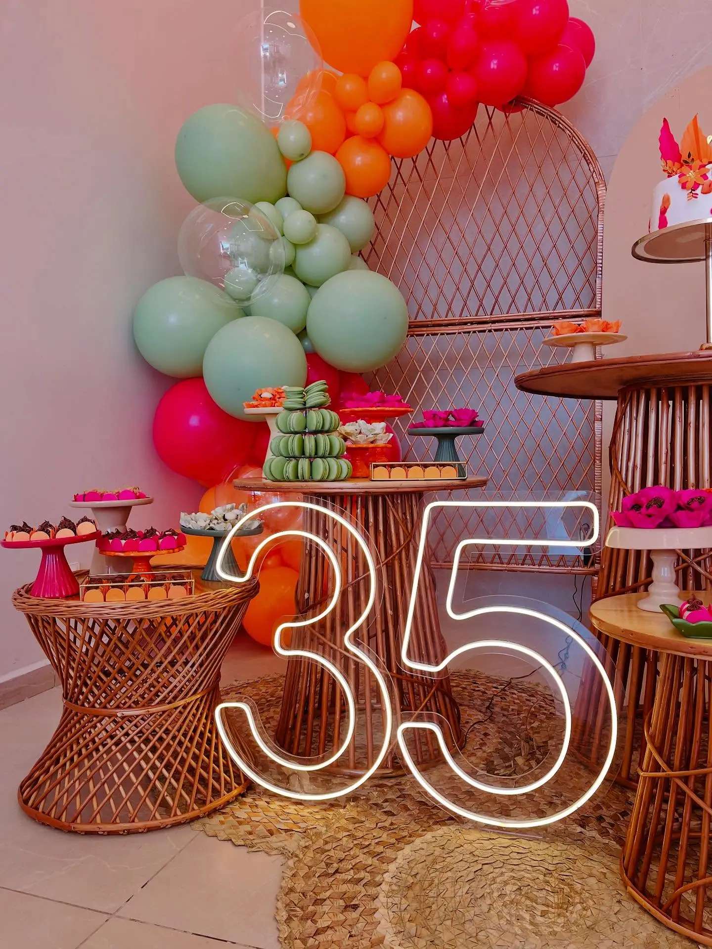 Mesa de aniversário com balões coloridos e número 35 iluminado