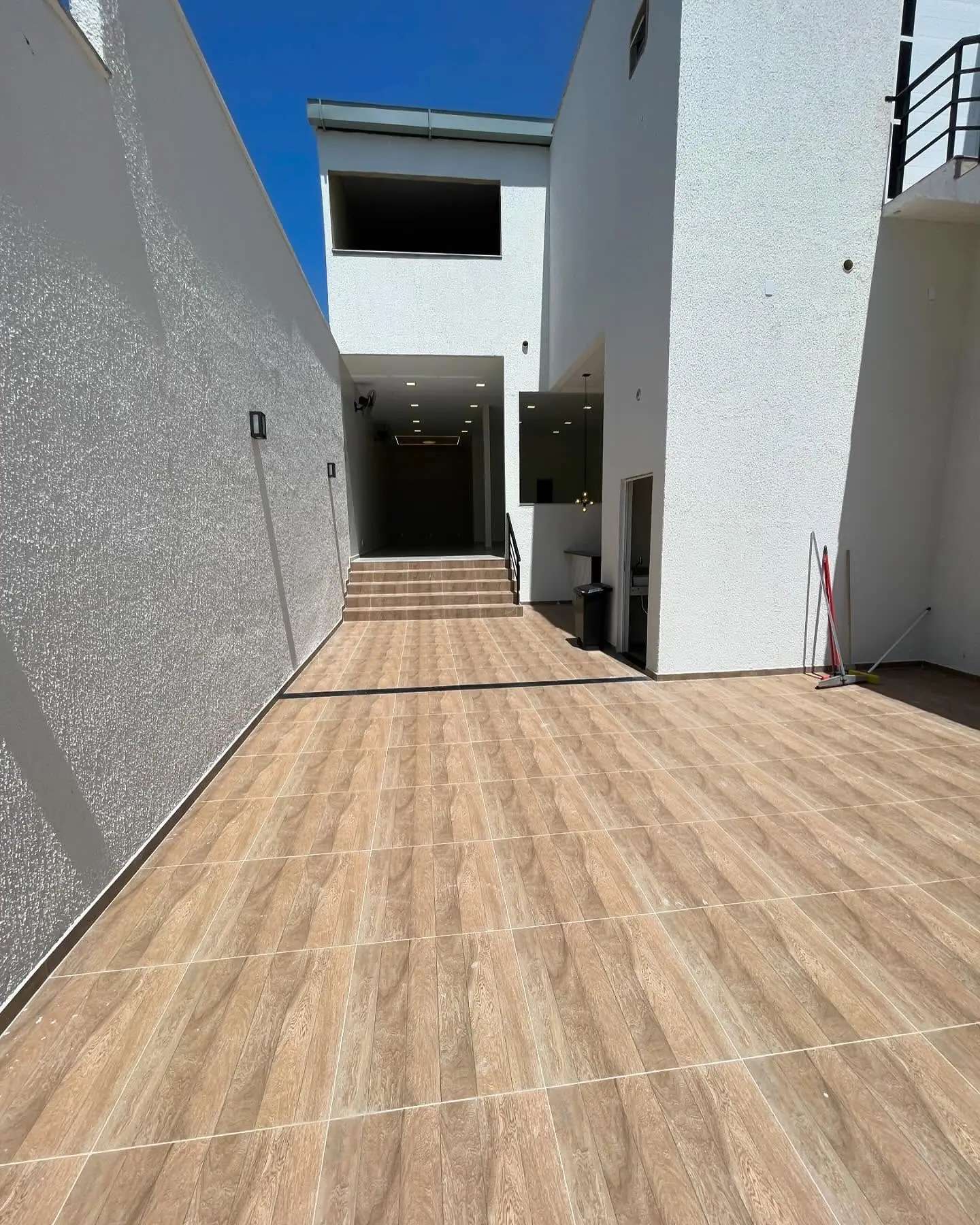 Área externa com escada lateral e entrada para o salão interno
