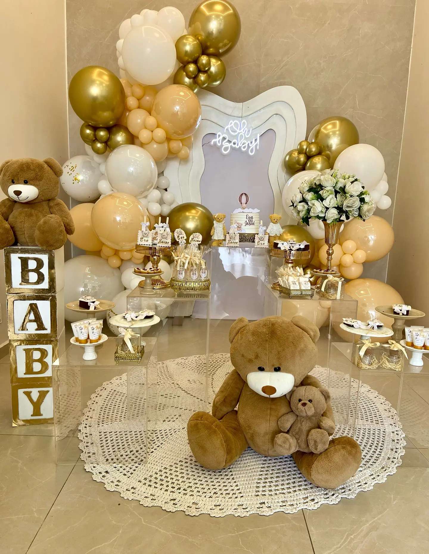 Decoração de chá de bebê com balões dourados e brancos, ursinhos e letras BABY