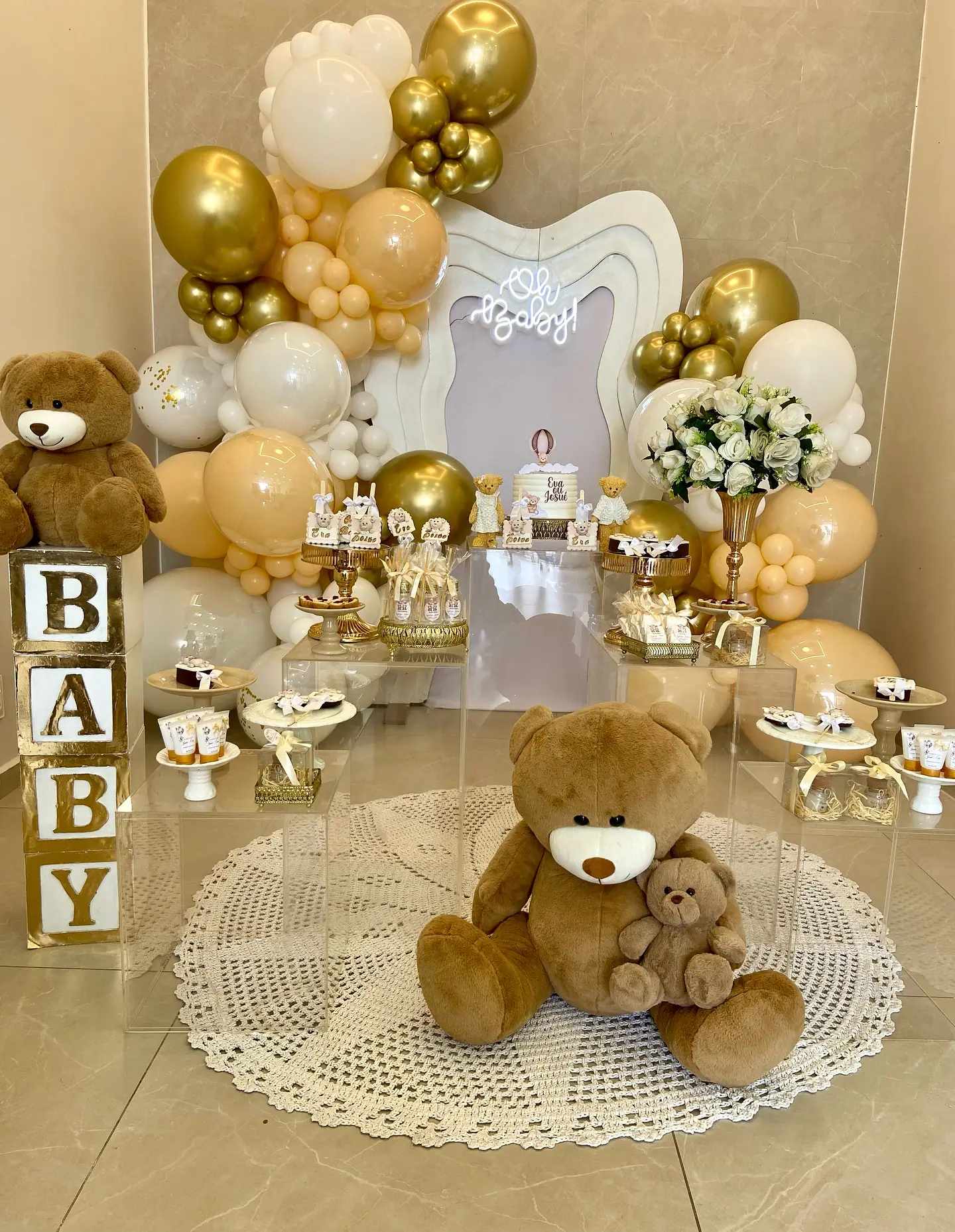 Decoração de chá de bebê com balões dourados e brancos, ursinhos e letras BABY
